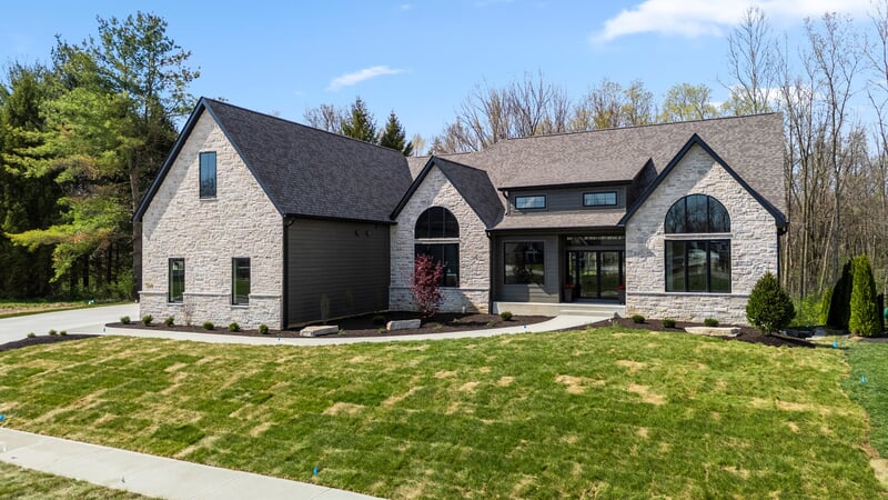 Front of a stone house with a green lawn