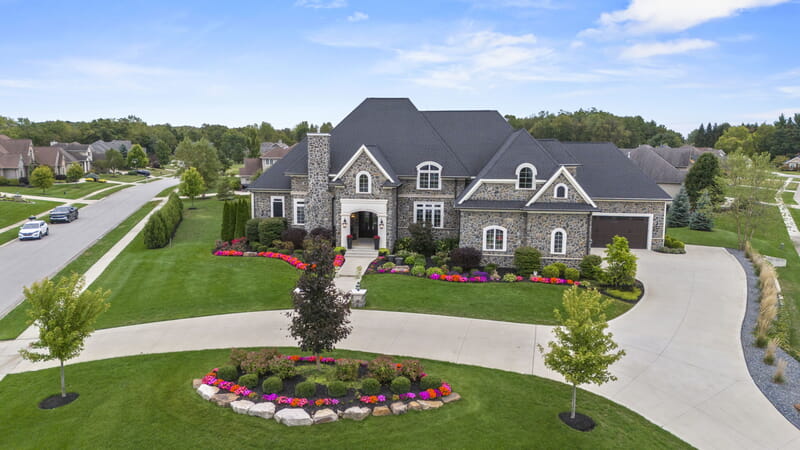 Angled view of a home from the front with a curved landscaped driveway